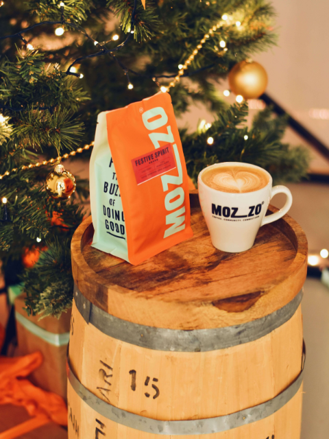 A Christmas spiced butter latte made with Mozzo coffee next to a twinkling Christmas tree