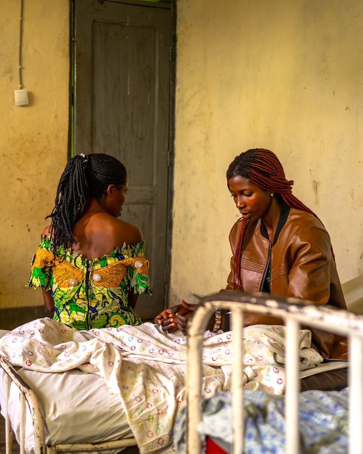 Two african women sitting on a hospital bed 