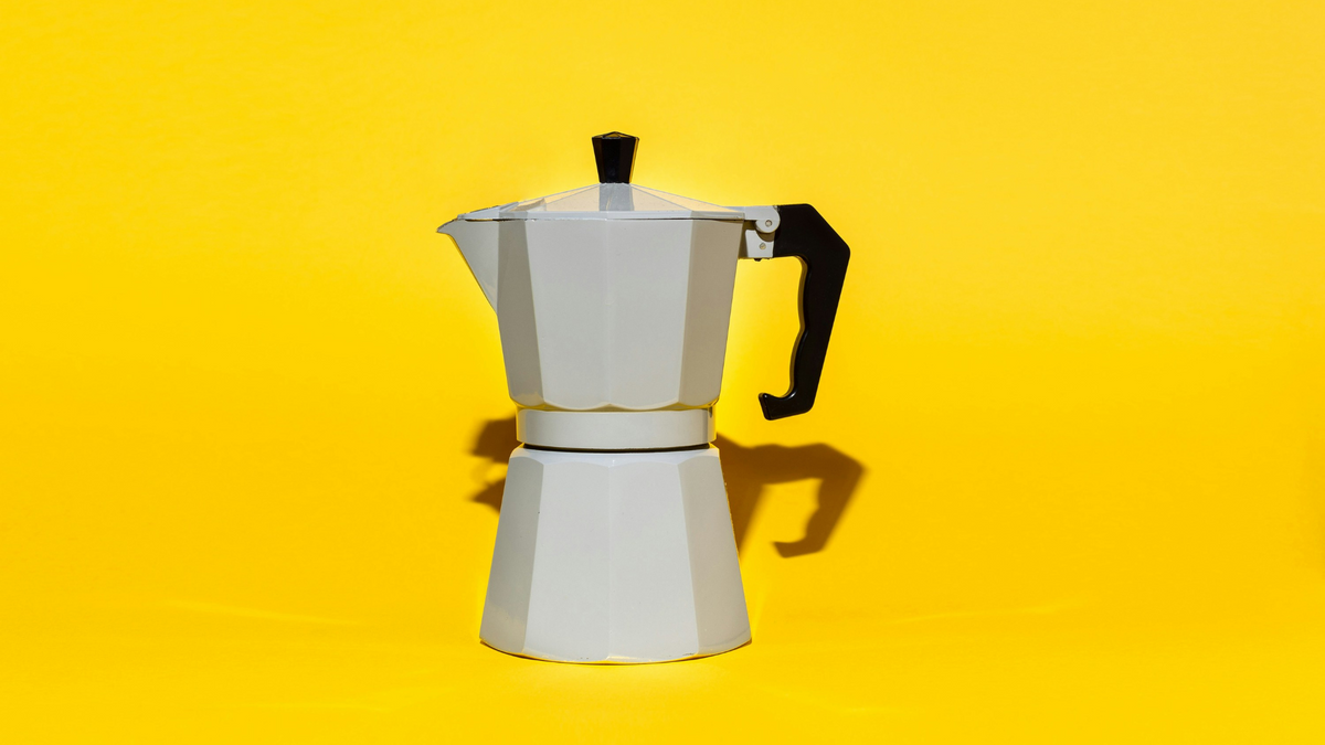 A traditional Moka Pot featured with a bright yellow background 