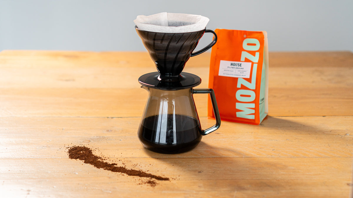 A v60 coffee filter brewing over a glass Chemex carafe 