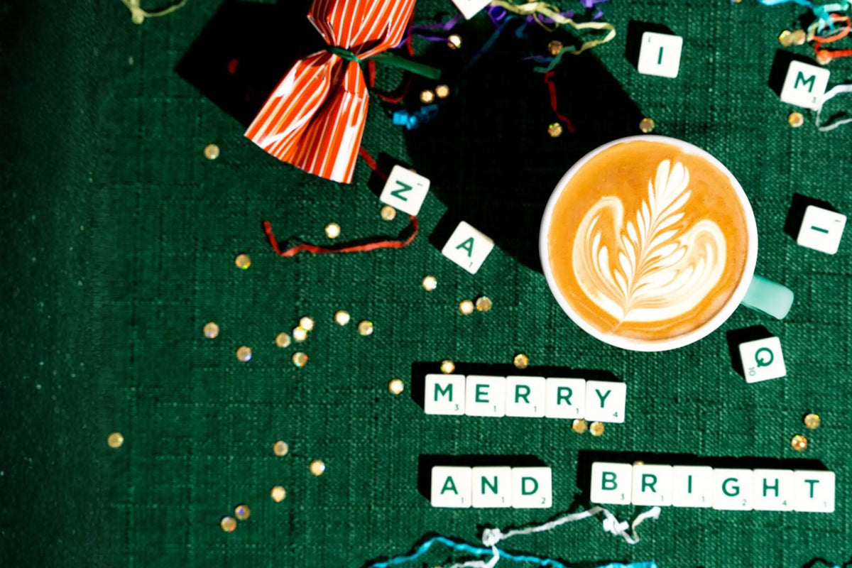 Latte surrounded by Christmas decorations, and 'Merry and Bright' spelt with Scrabble letters