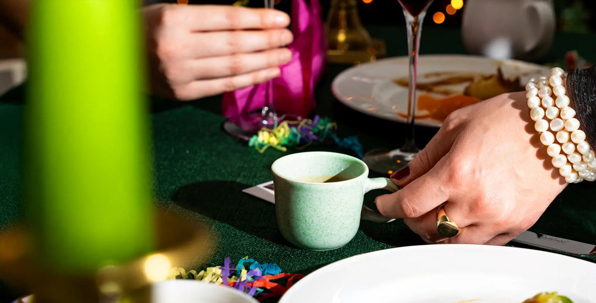 Espresso on a table with colourful ribbons and a blurred festive background
